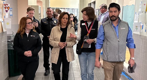 Photo of Kamala Harris walking down hallway with three Red Cross team members